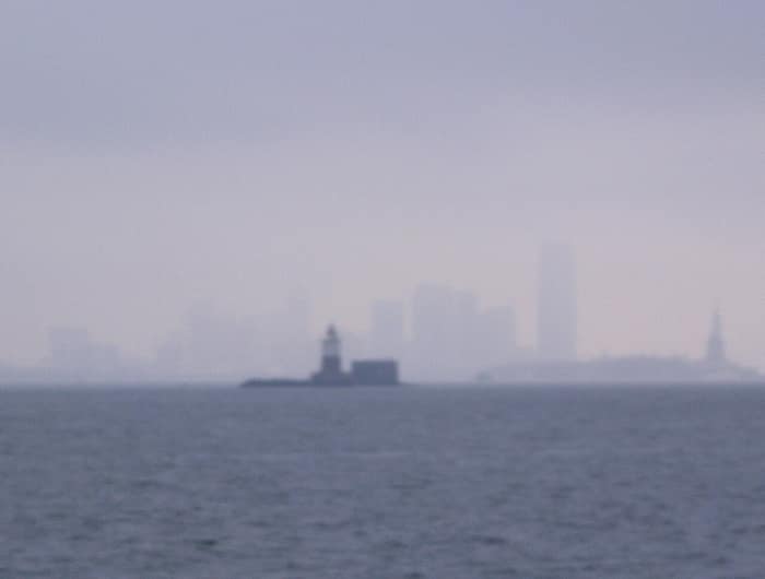 El faro de Robbins Reef emergiendo de la niebla en la bahía de Nueva York